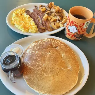 Pancakes, scrambled eggs with added cheese, thick bacon, and great home potatoes with a real mug of good coffee.