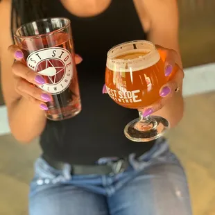 a woman holding two glasses of beer