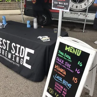 a black table with a black table cloth and a sign with white writing