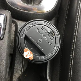 a coffee cup in the center console of a car