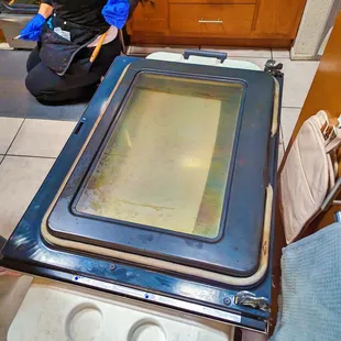 a man kneeling on the floor in front of an oven