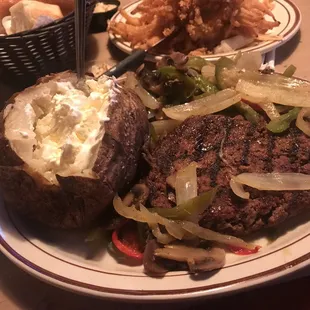 Baked potato with a chopped steak with onions,peppers and mushrooms