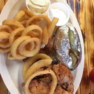 a plate of food with onion rings and a pickle