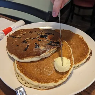 a plate of pancakes with butter and syrup