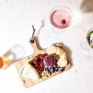 a cheese board with fruit and cheese