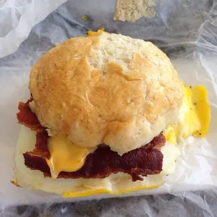 A delicious bacon, egg, and cheese biscuit sandwich.