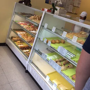 a man standing in front of a display case filled with donuts