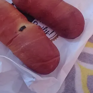 two hot dogs wrapped in bacon