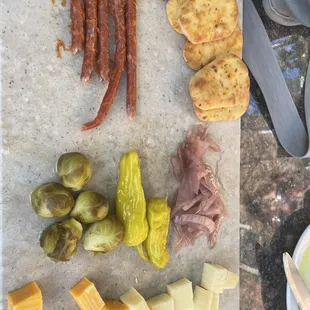 a variety of cheeses, meats, and pickles