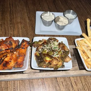 Pick 3: in order the West End style wings, crispy brussel sprouts, and truffle fries. The sauce order in back is blue cheese, aioli, ranch.