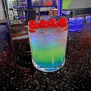 a colorful drink with cherries in it