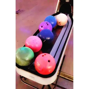 a row of bowling balls in a bowling alley