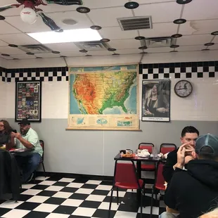 diners in a diner with a map on the wall