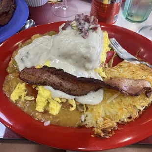 Breakfast enchilada, covered in biscuits and gravy, bacon and chipped beef