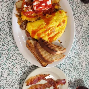 Home fries with cheese and onions, a meat lovers omelet, toast and a side of bacon.