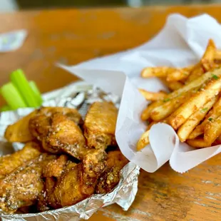 a basket of chicken wings and a basket of fries