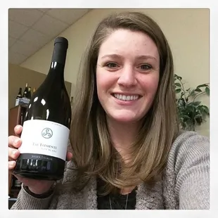 a woman holding a bottle of wine