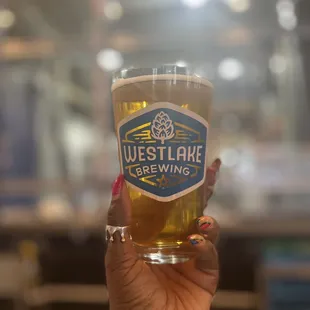 a hand holding a pint of beer