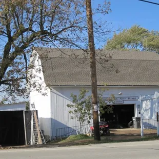 a white barn with a motorcycle parked in front of it