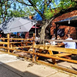 a man sitting on a bench under an umbrella