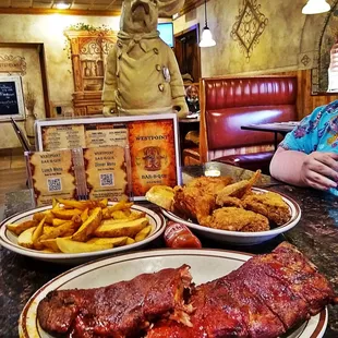 a man in a chef's hat sitting at a table with plates of food