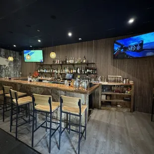 a bar with a television and bar stools