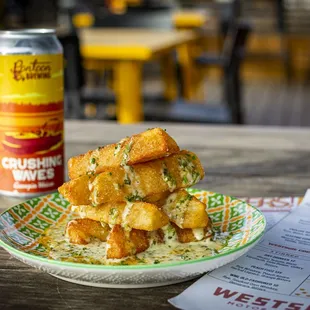 a plate of fried tater tots and a can of beer