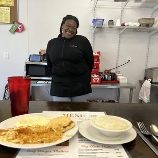 a woman standing behind a counter in a restaurant