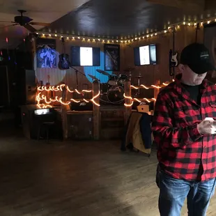 a man in a plaid shirt and jeans playing a video game