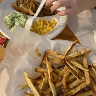 ows a plate of french fries and a plate of macaroni and cheese