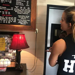 ows a woman standing in front of a menu