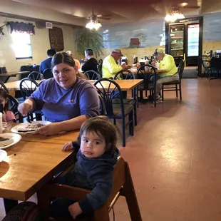 ows a woman and two children sitting at a table