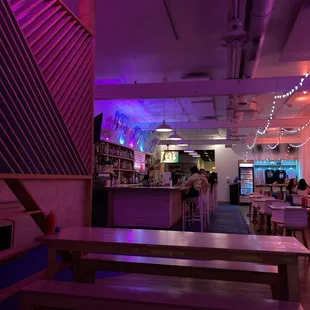 the interior of a restaurant with purple lighting