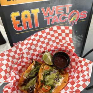 a person holding a basket of tacos