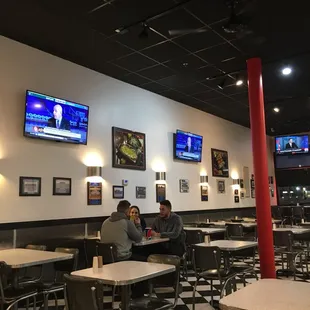 two people sitting at tables in a restaurant
