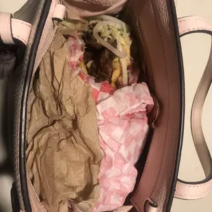 My purse stuffed with my husbands burger and fries
