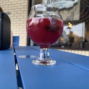 a glass of beer on a blue table