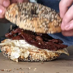 Our everything bagel, bacon, over easy egg and cheese sandwich being made