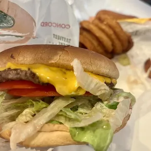 ows a hand holding a hamburger