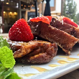 Grandma's slow cooked french toast bread pudding with fresh strawberry's and toasted coconut.