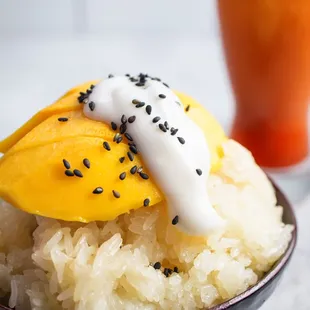 a bowl of rice topped with mango slices