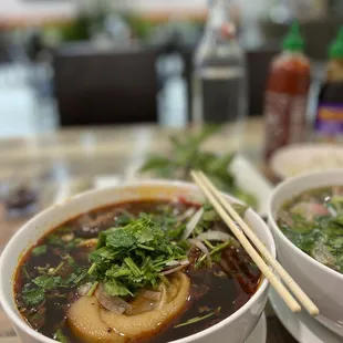 two bowls of soup with chopsticks