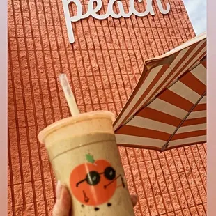 a hand holding a cup with a straw