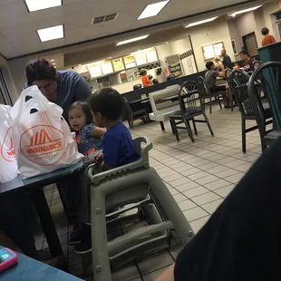 a child sitting at a table in a fast food restaurant