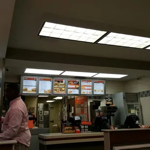 a man standing at the counter of a fast food restaurant