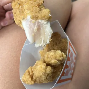 a person holding a piece of food