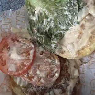 a sandwich with lettuce and tomatoes