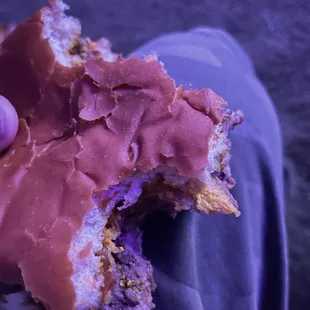 a hand holding a half eaten donut