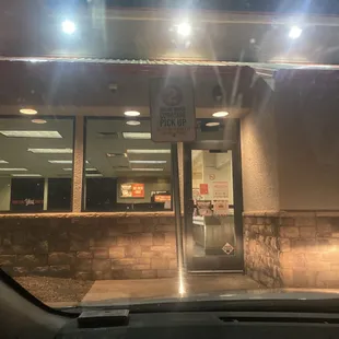 a parking meter in front of a pizza place