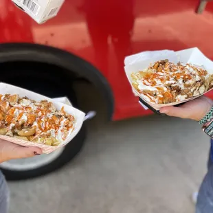 two people holding plates of food